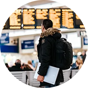 Traveler at airport with laptop for Sakura Mobile SIM/eSIM support in Japan.